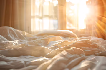Cozy bedroom with morning light, book on white linen
