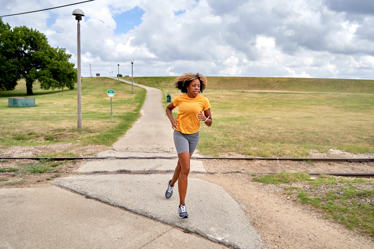 Woman jogging down a path in a park, fitness for busy people outdoors