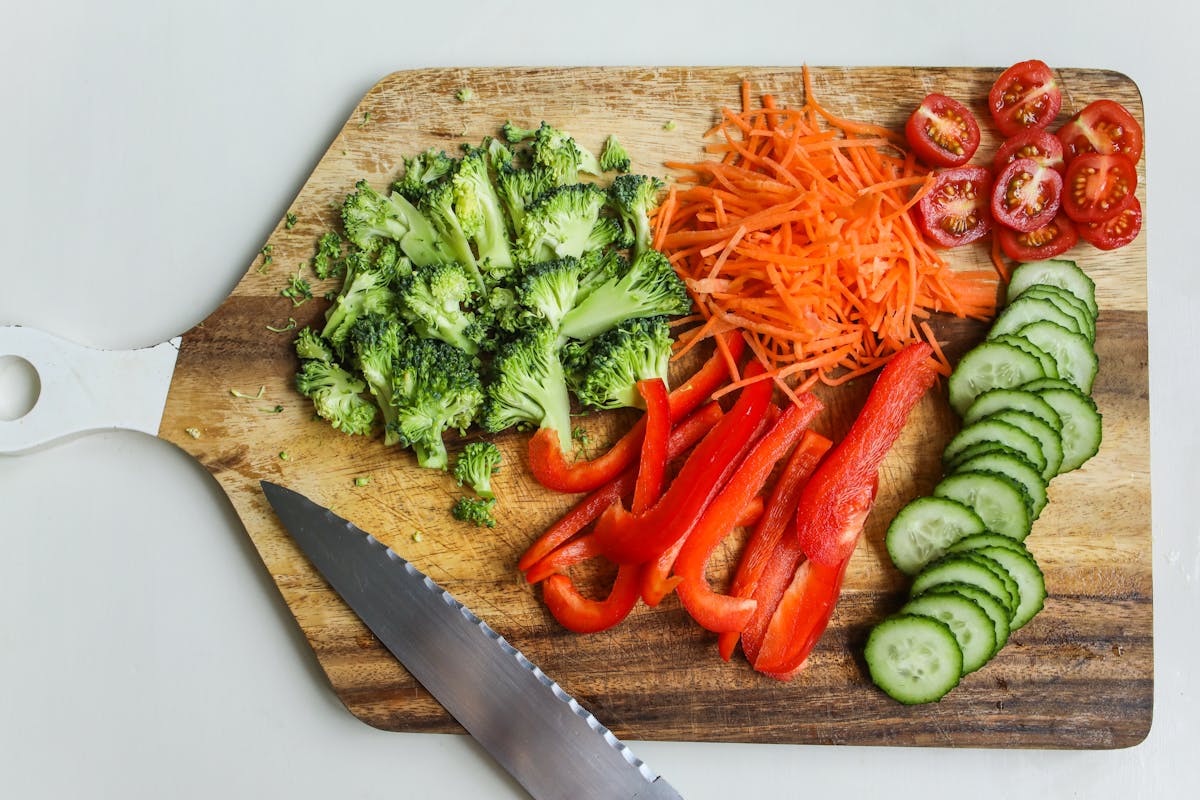 Colourful fresh vegetables on a wooden chopping board — mindful food preparation