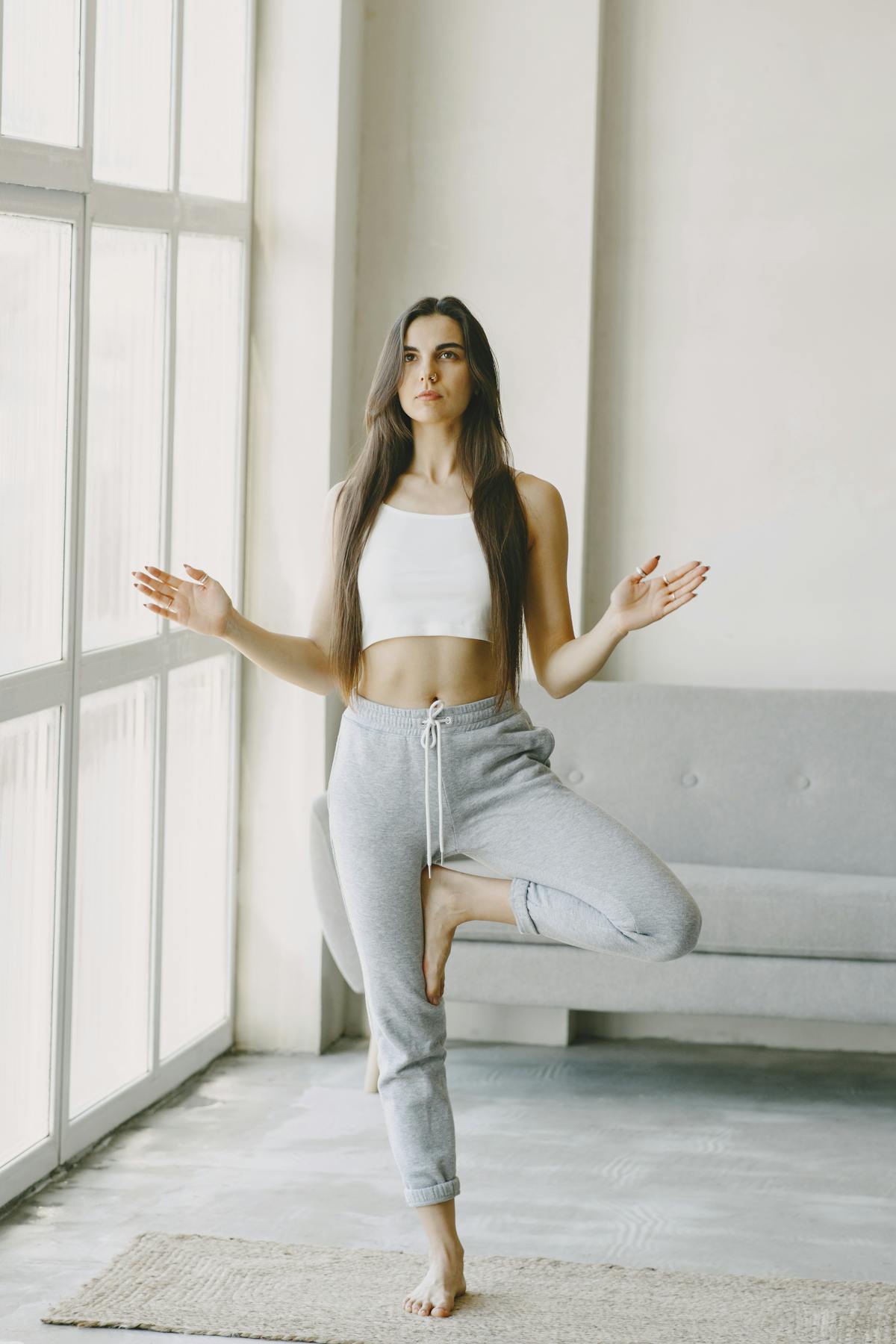 Woman practising yoga indoors by a bright window — movement and mindfulness as stress relief tools